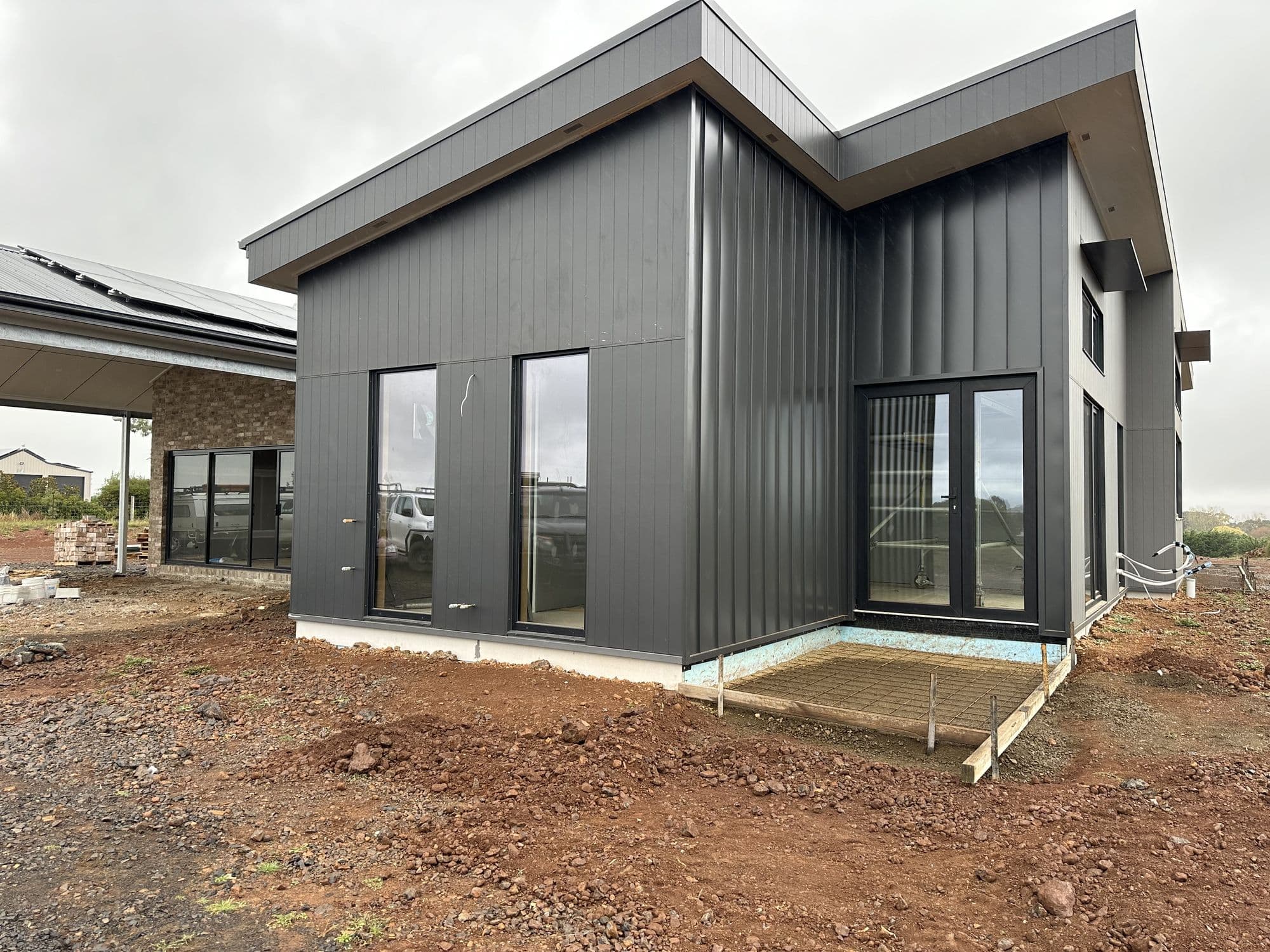 Single-storey charcoal new-build exterior with clean black window frames